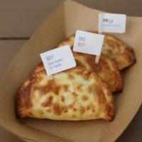 Eggplant Parmigiano Empanada · Light pastry wrappers filled with premium ingredients and baked to order.