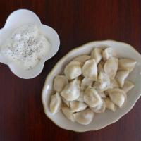 Russian Pelmeni (dumplings) · Made with chicken, beef, potato & onions. Comes with sour cream, butter and ground black pep...
