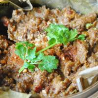B4. Lotus Beef · Steamed with peppers, cilantro and garlic in lotus leaf. Spicy.