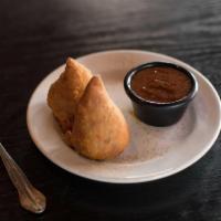 Vegetable Samosa · 2 samosas filled with spiced potato, cabbage, green onion, peas wrapped in a thin layer of f...
