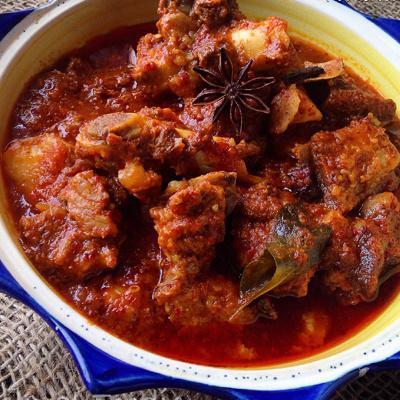 Goat Vindaloo · Goan dish seasoned goat cubes cooked in rich spicy tangy with potatoes, coconut and curry leaves.