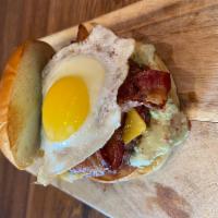 El Paso Burger · 8oz Beef Burger, sunny side egg, 2 strips of bacon, cheddar cheese, and jalapeño aioli.
