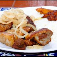 Masas de Cerdo Fritas · Fried pork chunks. Served with onion and garlic mojo, white rice, black beans and 3 plantains 
