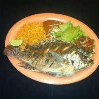Mojarra Frita · Fried mojarra fish with beans, rice, salsa guacamole, lettuce and tortillas.