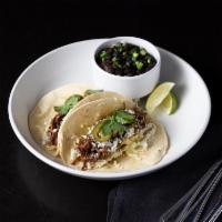 Braised Beef Taco · Queso fresco, jalapenos, cilantro and aji pepper aioli. Two tacos per order; served on corn/...