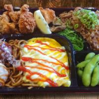 Deluxe Omusoba Bento · Omelette over pork yakisoba with ketchup and mayo, chicken karaage, stewed beef over rice, t...