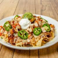 Nachos Supremos · Chicken on a mound of warm chips, melted cheese, refried beans and guajillo chile sauce topp...