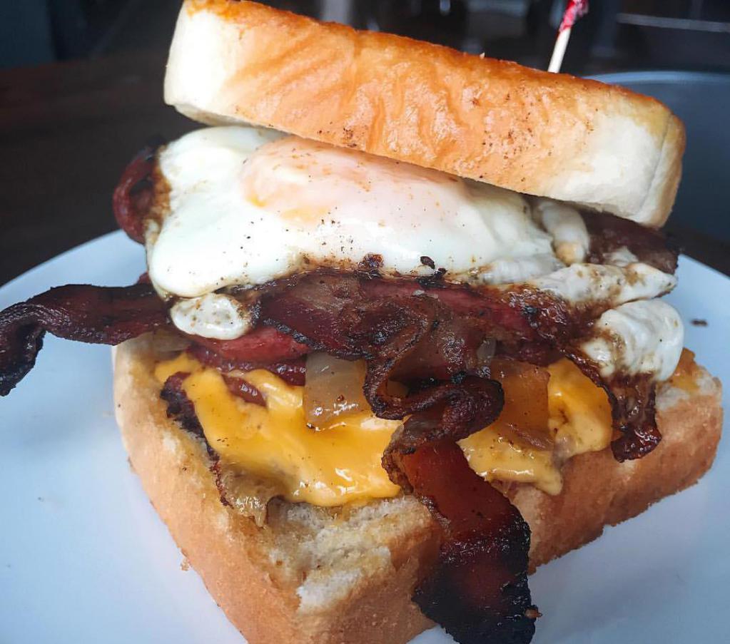 The Stache Favorite · Housemade bologna, smoked thick-cut bacon, caramelized onions, melted American cheese and a tangy Carolina mustard on grilled garlic bread. Served with house seasoned chips.