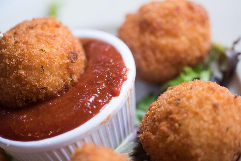 Fried Risotto Balls · Italian rice balls stuffed with ground beef and mozzarella cheese, coated with panko crumbs and fried to a golden brown. Served with marinara sauce.