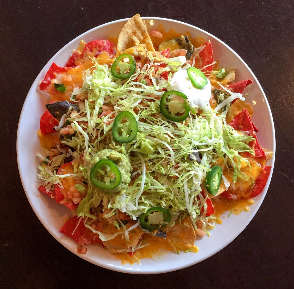 Nachos · Corn tortilla chips, cheddar and Jack cheese, shredded lettuce, chopped onion, diced tomato and fresh jalapeno, served with guacamole, sour cream and fresh pico de gallo. Add chili, pulled pork or chicken for an additional charge. Gluten sensitive.