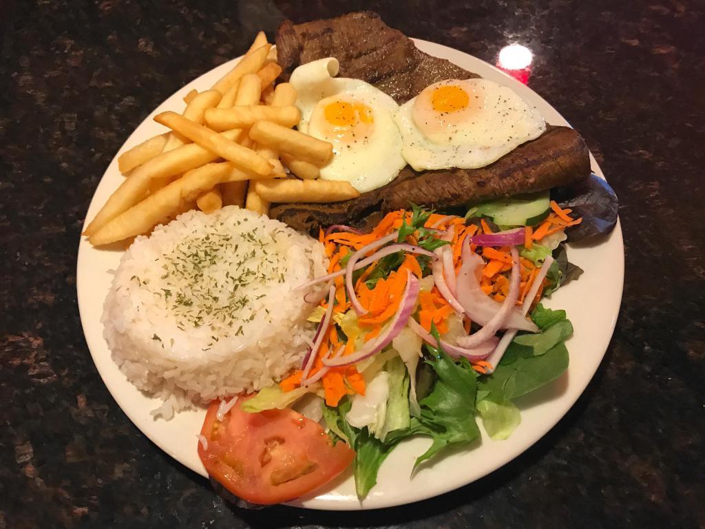 49. Steak de la Casa · Grilled steak, rice, salad, fried eggs and french fries.