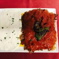 Iskender Kebab Plate · Thinly sliced roasted lamb served over sliced pita, covered in a tomato and butter sauce. Se...