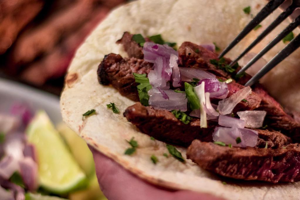 Steak Tacos · Served with red onion, serrano peppers, avocado, and cilantro.