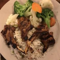 Lamb Chops Entree · Cooked over char-grill with herb butter served with side of rice and fresh vegetables.
