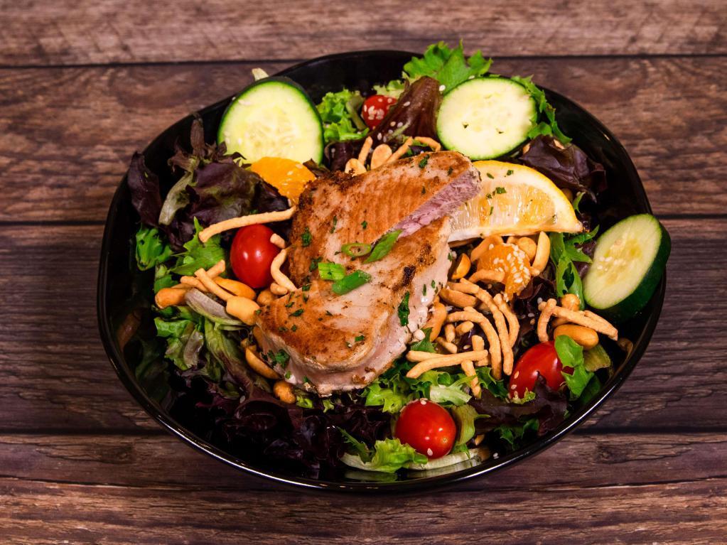Asian Tuna Salad · Baby mixed greens, crispy chow mein noodles, mandarin oranges, sesame seeds, cucumbers, peanuts and tomatoes all tossed with Wasabi vinaigrette and topped seared tuna steak with a brush of soy sauce