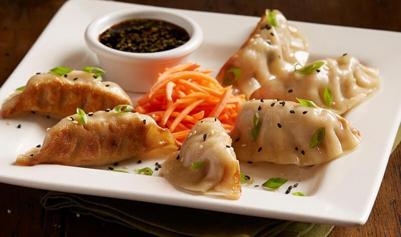 Chicken Pot Stickers · Pan-seared dumplings, chicken, ginger, garlic, yellow chives, green onions, soy ginger sauce, sesame seeds