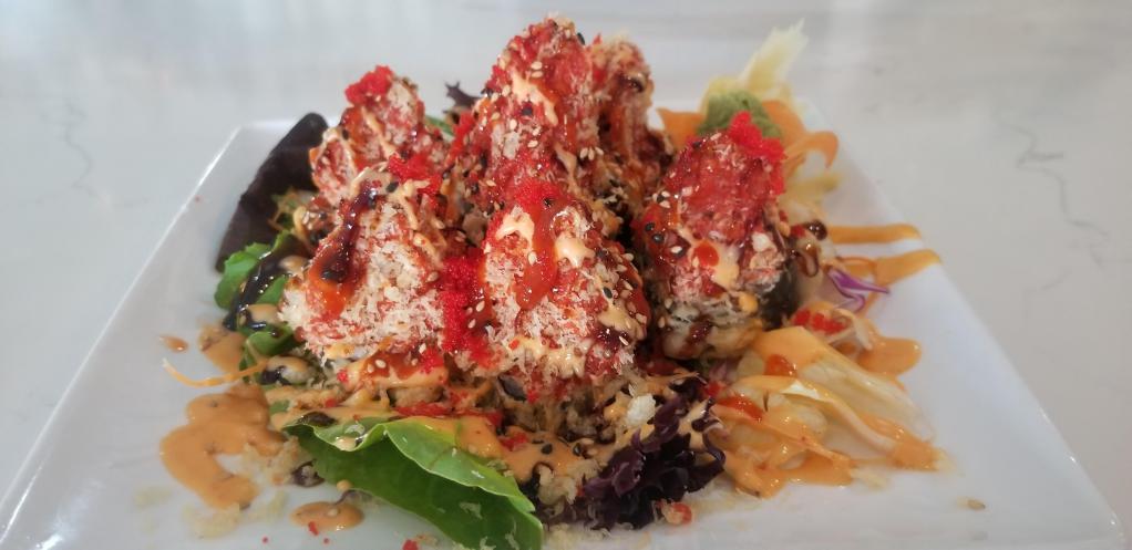 Volcano Roll · Fried cream cheese, eel, smoked salmon topped with spicy tuna, flake, eel sauce, spicy mayo, hot sauce and masago.