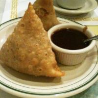Samosa · Deep fried pastries filled with potatoes and peas, served with tamarind chutney. Vegetarian.