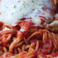 Chicken Parmigiana · Breaded chicken breast with marinara sauce and mozzarella cheese on a bed of fettuccine. A g...