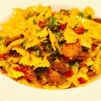 Farfalle Alla Barese · Bowtie pasta with Italian mild sausage, broccoli and sun-dried tomatoes in a roasted garlic ...