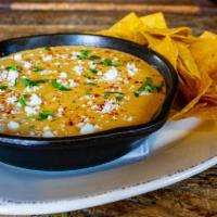 Queso Fundido · Melted cheese, black beans and pico de gallo, topped with queso fresco and avocado aioli