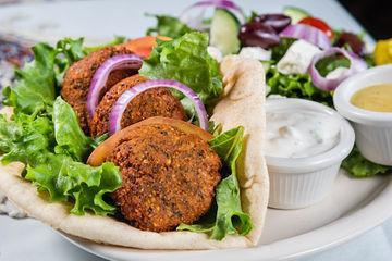 Falafel and Hummus Plate · Hummus spread on pita bread topped with falafel. Served with Greek salad and rice.