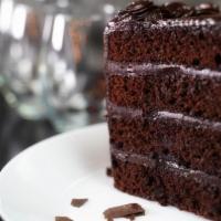 Chocolate Fudge Cake · Moist chocolate fudge cake, layered with rich buttercream, covered in milk chocolate shavings.