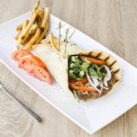 Spartan Bifteki · Greek Burger. Juicy ground beef patty with chopped onions and herbs on pita bread with tzatz...