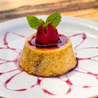 Crema Volteada · Peruvian flan. Custard made with pisco, topped with our strawberry-rocoto and wine sauce. Gl...