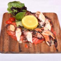 Pulpo a la Parrilla · Grilled to perfection, octopus with tomato salad.