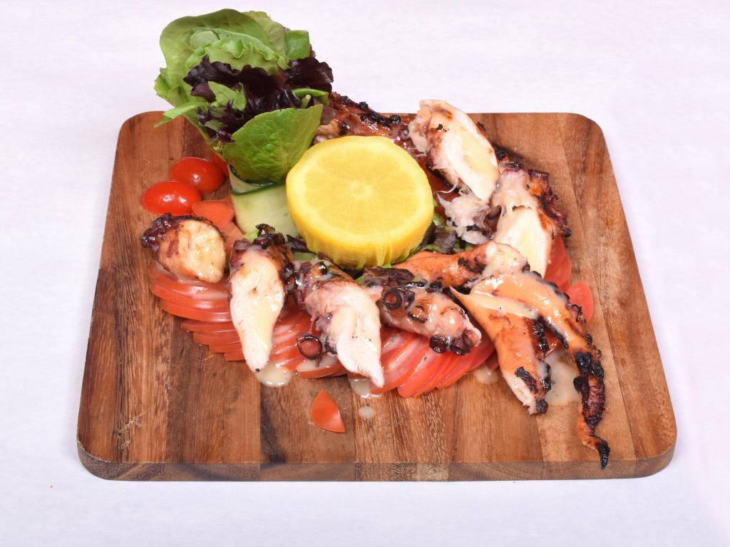 Pulpo a la Parrilla · Grilled to perfection, octopus with tomato salad.