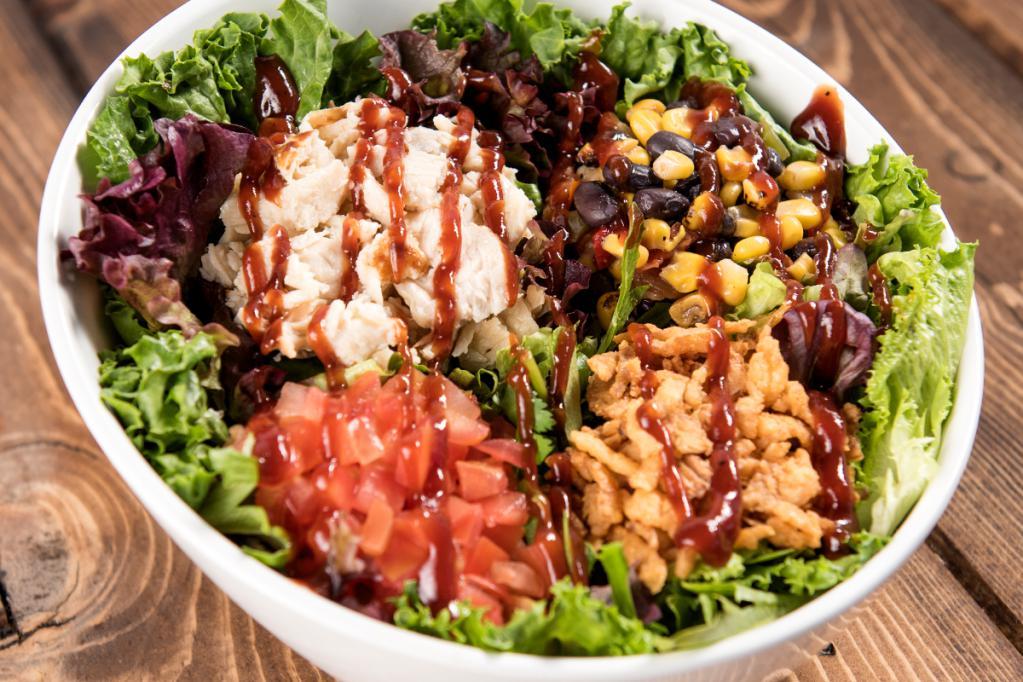 BBQ Chicken Salad · Slow roasted chicken, mixed greens, crispy cheddar onions, diced tomatoes, corn, and black bean mix, chipotle ranch dressing and BBQ sauce.
