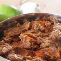 Lamb Vindaloo · Boneless lamb cooked with potatoes, onions, garlic, tomatoes, vinegar and spices. Served wit...