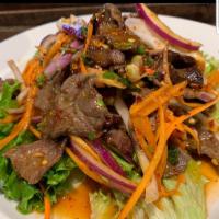 44. Crazy Beef Salad · Thinly sliced beef mixed with with ground roasted rice, lime juice, red onions, scallion, ci...