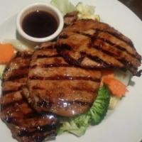 53. Siam Pork Chop · Marinated park chop fire grilled with garlic sauce, served with seasonal vegetables and chil...