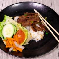 41. Grilled Pork Rice Plate · Dished up with white rice, slices of cucumbers and tomatoes along with pickled radishes. Ser...