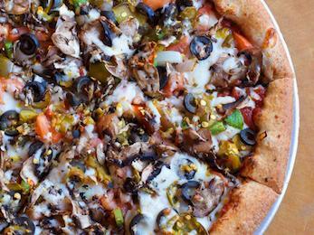 Classic Veggie Pizza · Black olive, onion, mushroom, green peppers, Italian sweet peppers, tomato and smoked provolone cheese on hand tossed honey whole wheat crust. Vegetarian. 