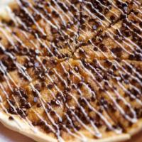 Chocolate Chip Pizza · Crispy thin crust and cookie dough topped with hot and melty chocolate chips and drizzled wi...
