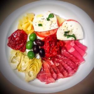 Antipasto del Buongustaio · Assortment of cold cuts with fresh mozzarella, Parmigiano cheese roasted peppers, artichokes, sun-dried tomato and olives.