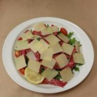 Carpaccio di Manzo · Thin slices of raw beef filet mignon topped with arugula, cherry tomatoes, Parmigiano cheese...