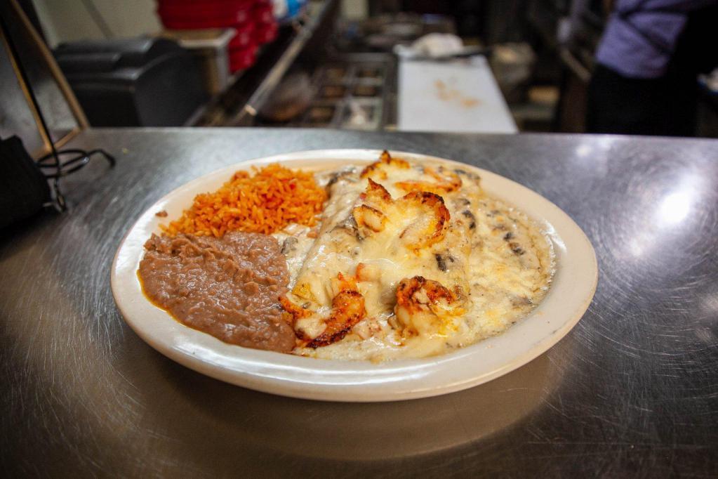 Shrimp Enchiladas Lunch · White cheese enchiladas topped with sauteed shrimp and topped with mushroom sauce. Served with rice and beans.