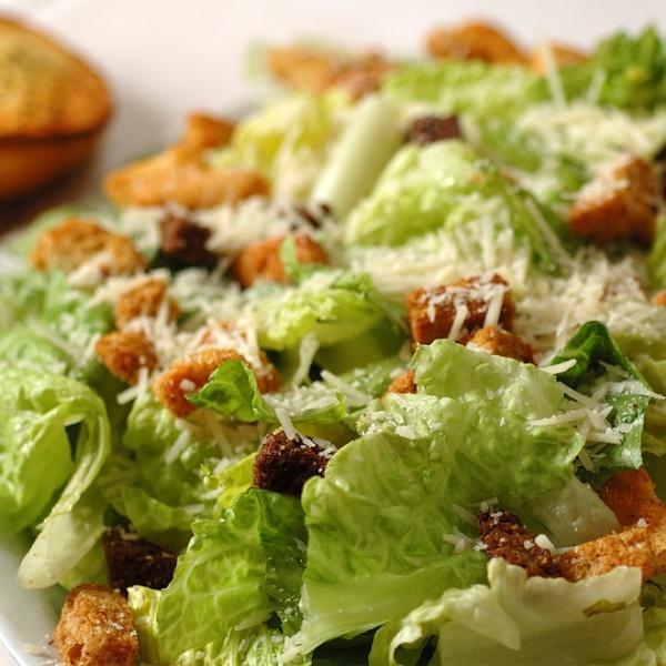 Caesar Salad · Fresh romaine, garlic croutons, fresh grated Parmesan cheese, Caesar dressing and garlic bread.