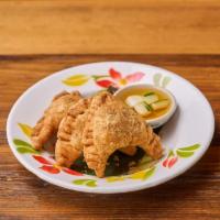 Curry Puff · Savory pastry pockets stuffed with curried chicken, potatoes, peas and carrots.