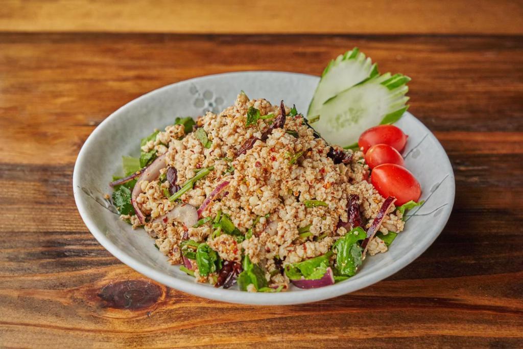 Labb Moo · Cooked ground pork, seasoned with red onion, scallion, mint leaves, grounded roasted rice, chili and lime juice. 