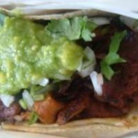 Al Pastor Taco · Marinated pork slowly cooked to perfection served on corn tortilla and topped with fresh gua...