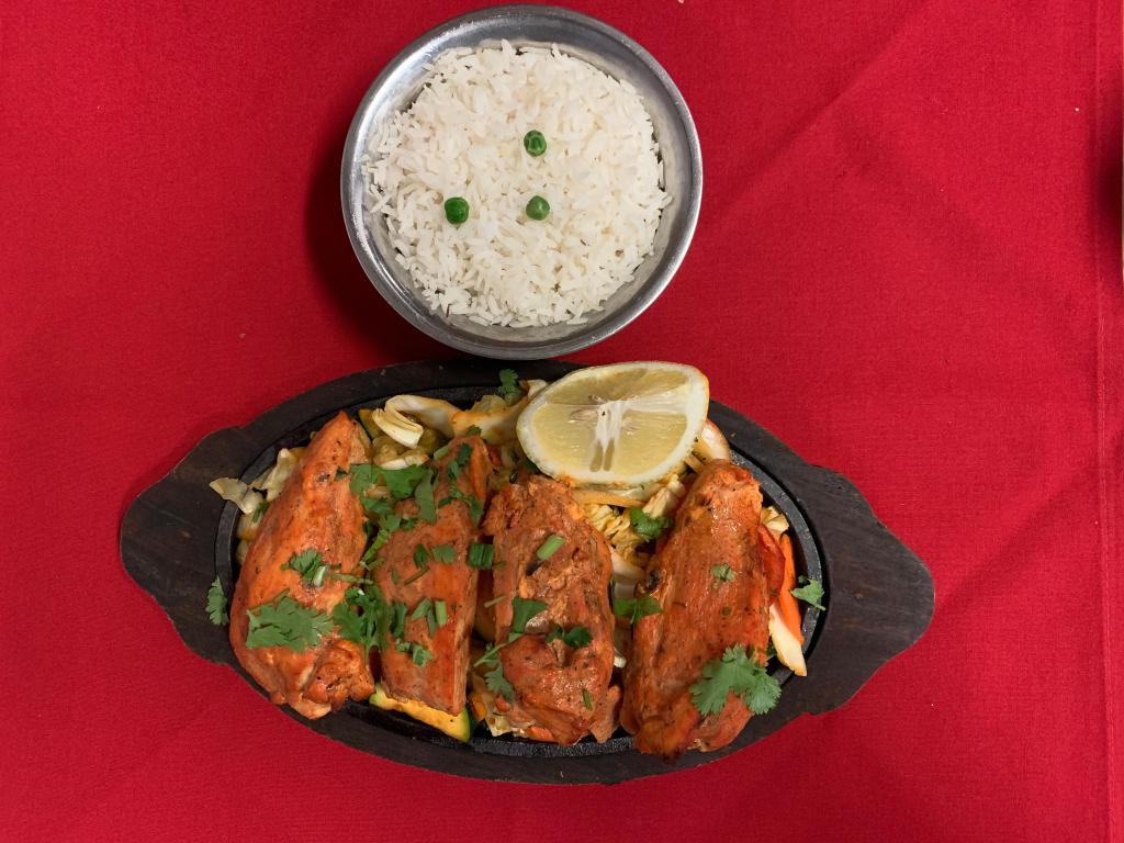 Chicken Tikka Tandoori  · Boneless chicken breast first marinated with special herbs, spices along with yogurt, then baked to perfection in the tandoor oven and served sizzling with onion, bell pepper, cabbage and carrot. Served with basmati rice.