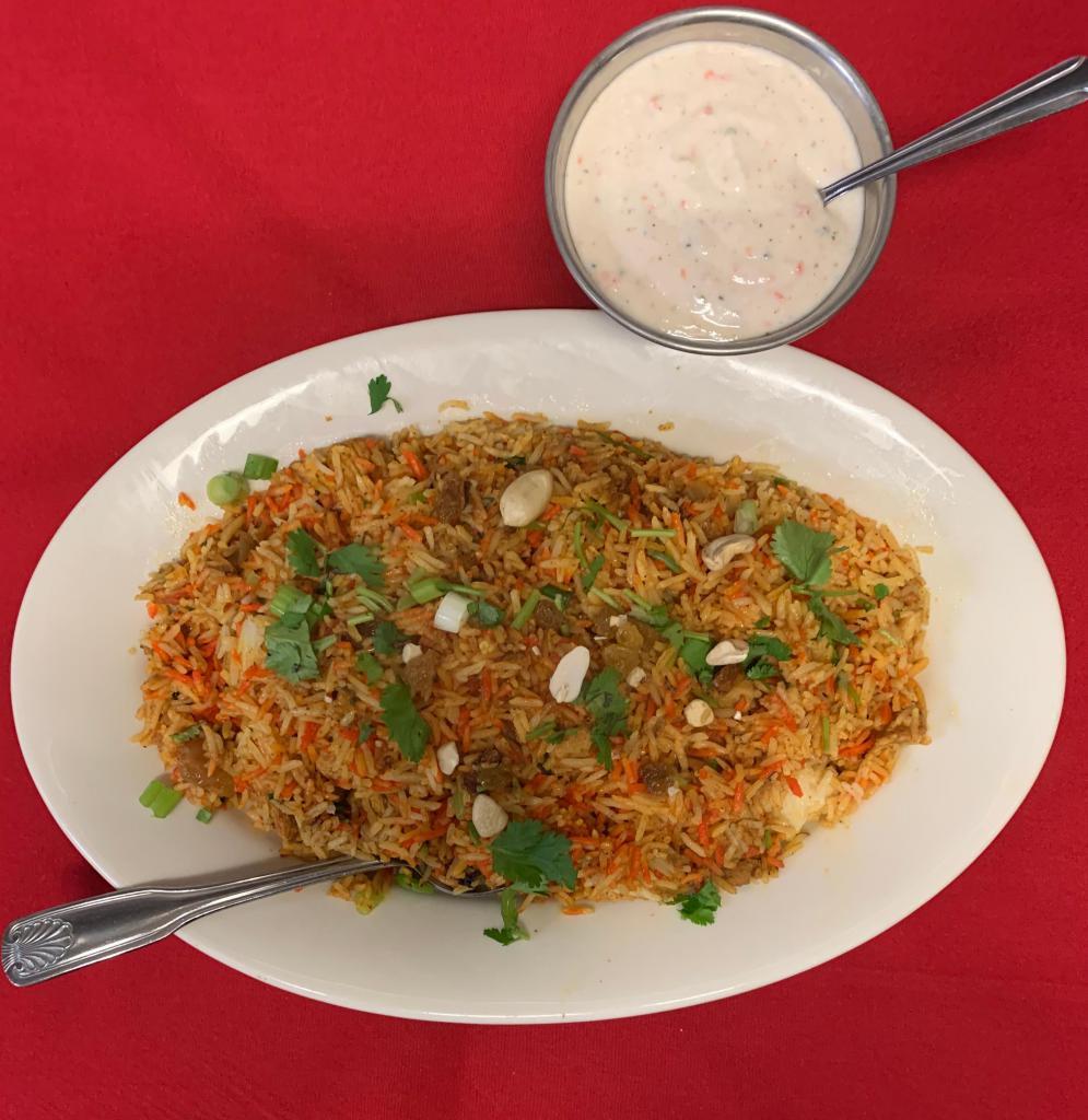 Chicken Biryani · Premium chicken cooked with basmati rice with a mix of special herbs and spices. Served with raita.