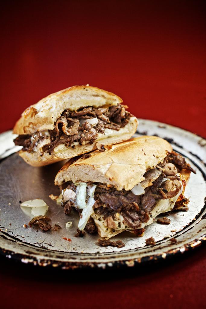 Philly Cheesesteak Sandwich · Seasoned grilled steak, onions, and mushrooms with white American and smoked provolone cheese. Served up toasty on a Tuscan baguette.