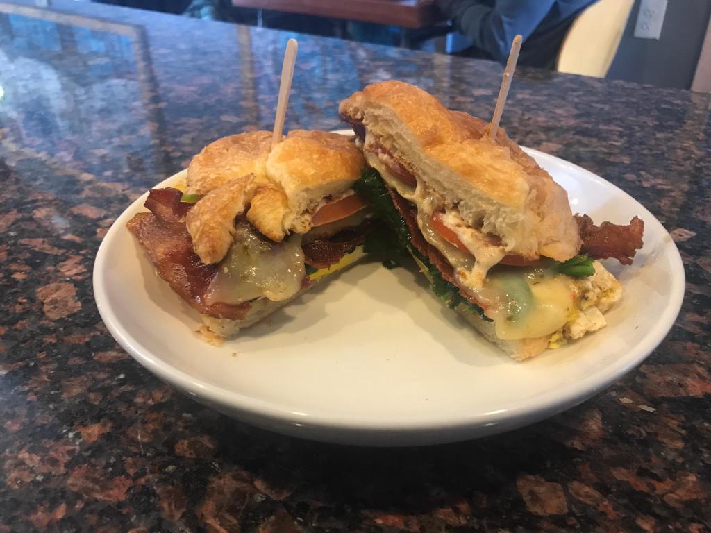 Zesty Breakfast Sandwich · Two over medium eggs together with pepper jack cheese, tomatoes, spinach and bacon and placed on a buttery toasted croissant.