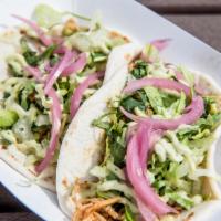 Chicken Tinga Tacos · 2 street style tacos. Chipotle-braised shredded chicken breast, topped with pickled red onio...